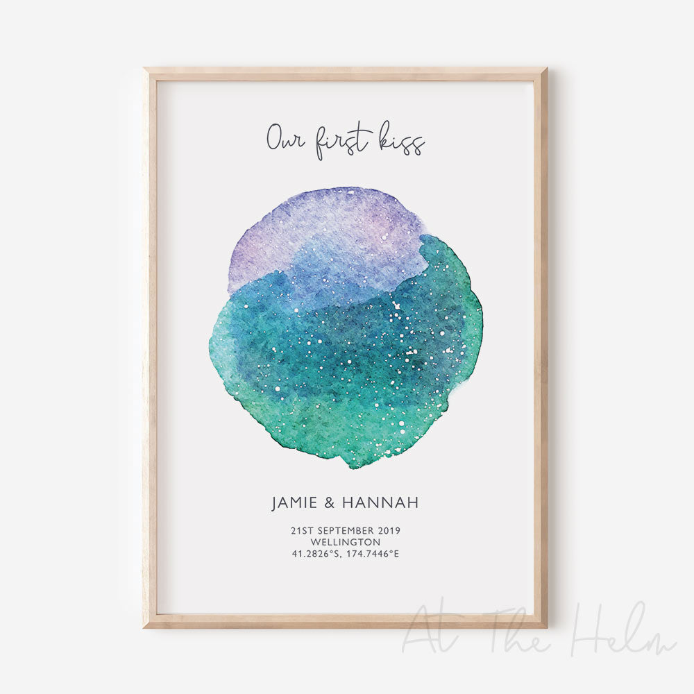 Framed custom blue, purple and green watercolour star map print with text personalization.
Headline text reads " Our First Kiss". Secondary text at the bottom reads " Jaime & Hannah" and then a personalised special date, location and map coordinates.