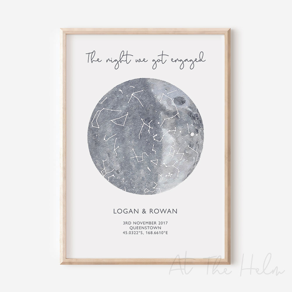 Framed custom grey watercolour star map print with text personalization.
Headline text reads " The Night We Got Engaged". Secondary text at the bottom reads " Logan & Rowan" and then a personalised special date, location and map coordinates.