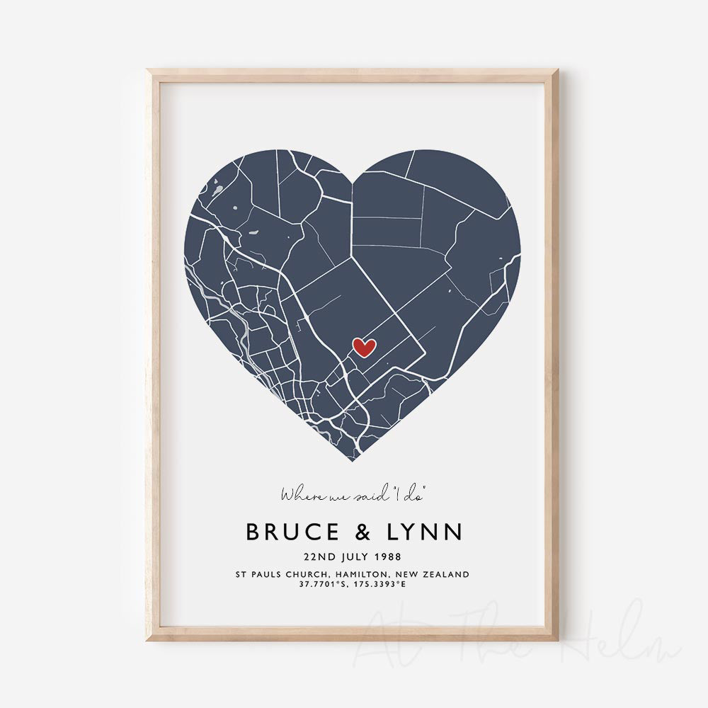 Framed blue and white heart-shaped map print with text personalization.

A red heart marks a specific location. 
Small cursive headline text reads " Where we said "i do"". Secondary capitalized text (slightly larger) below that reads " Bruce & Lynn"  and then a personalised special date, location and map coordinates. 