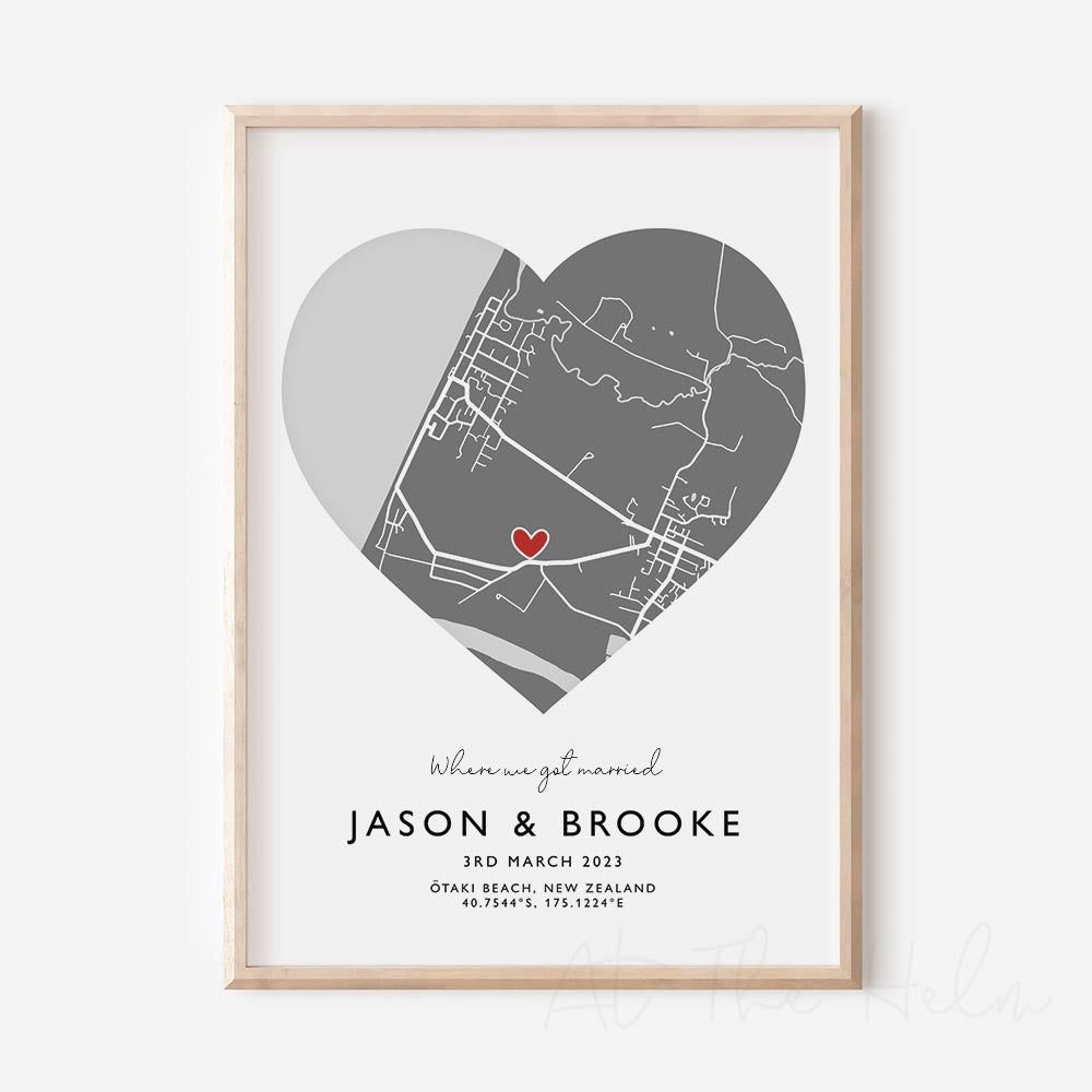 Framed grey and white heart-shaped map print with text personalization.

A red heart marks a specific location. Small cursive headline text reads " Where we got married". Secondary capitalized text (slightly larger) below that reads " Jason & Brooke"  and then a personalised special date, location and map coordinates. 