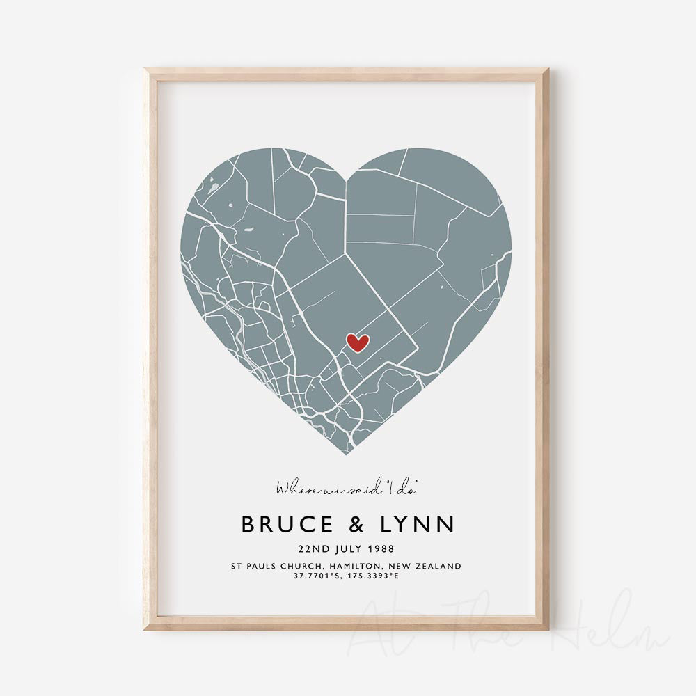 Framed light blue and white heart-shaped map print with text personalization.

A red heart marks a specific location. 
Small cursive headline text reads " Where we said "i do"". Secondary capitalized text (slightly larger) below that reads " Bruce & Lynn"  and then a personalised special date, location and map coordinates. 